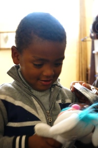 Mohammed receiving a gift from Ella and Nate (photo by Bob Haynes)